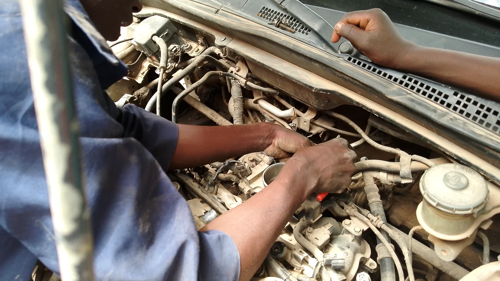 Mécanicien qui contrôle le moteur d'une voiture d'occasion avant achat